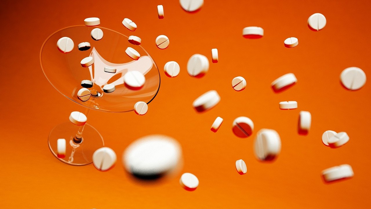 elderly person taking pill with glass of water
