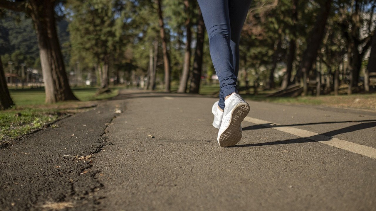 runner holding painful heel on trail