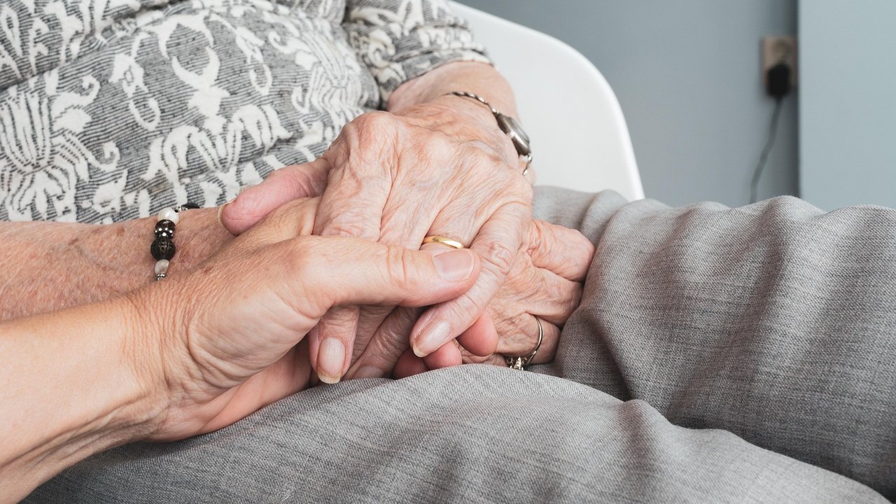 elderly woman walking outdoors with physical therapist